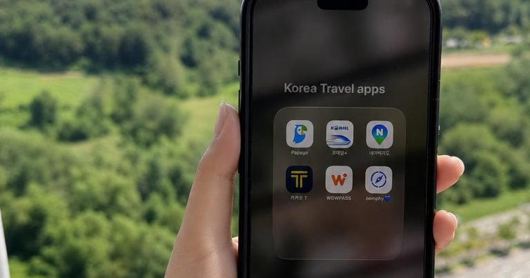Hand holding a smartphone with essential Korea travel apps
