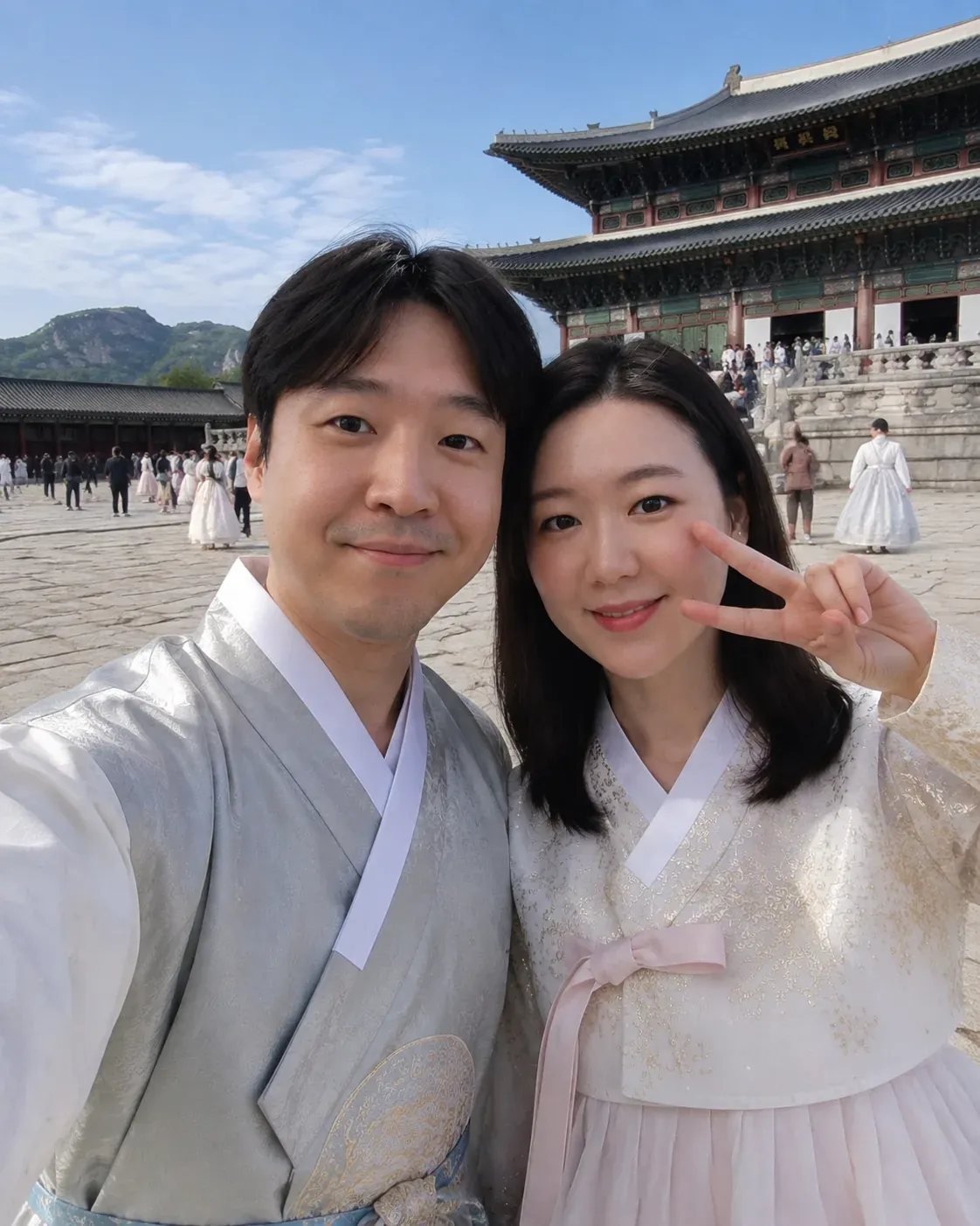 Couple taking a selfie in traditional Korean hanbok at Gyeongbokgung Palace