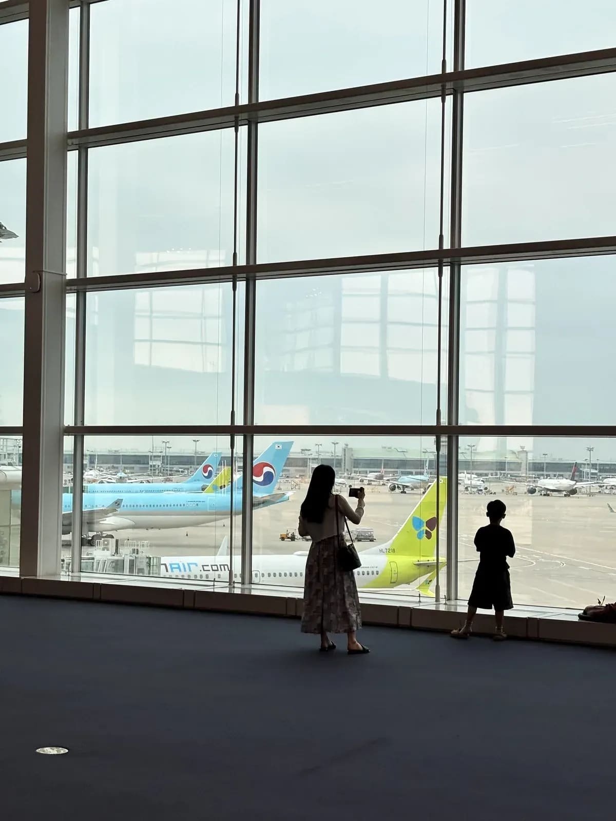 Traveler looking at airplanes on the tarmac at Incheon Airport during the first 24 hours in Seoul