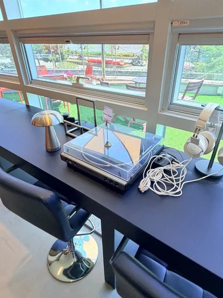 Window-facing counter seating with headphones for solo travelers dining and relaxing in Korea