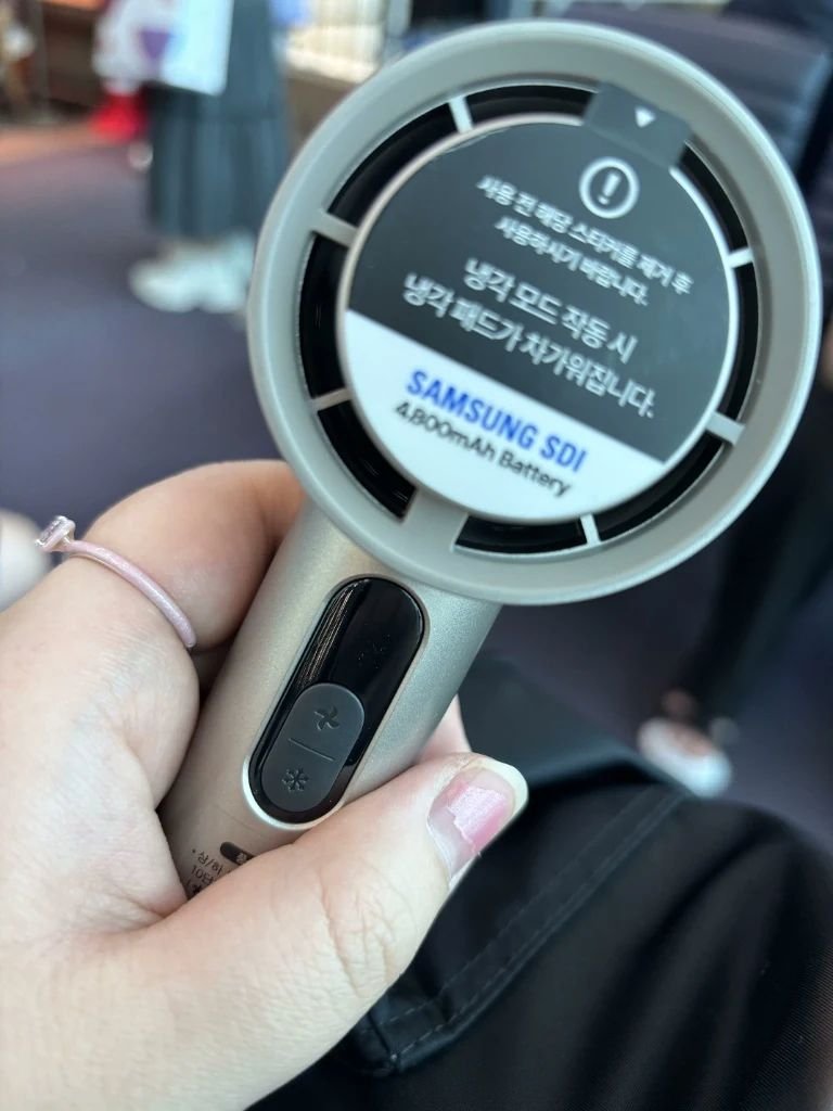 Close-up of a portable handheld cooling fan used for hot Korean summer travel
