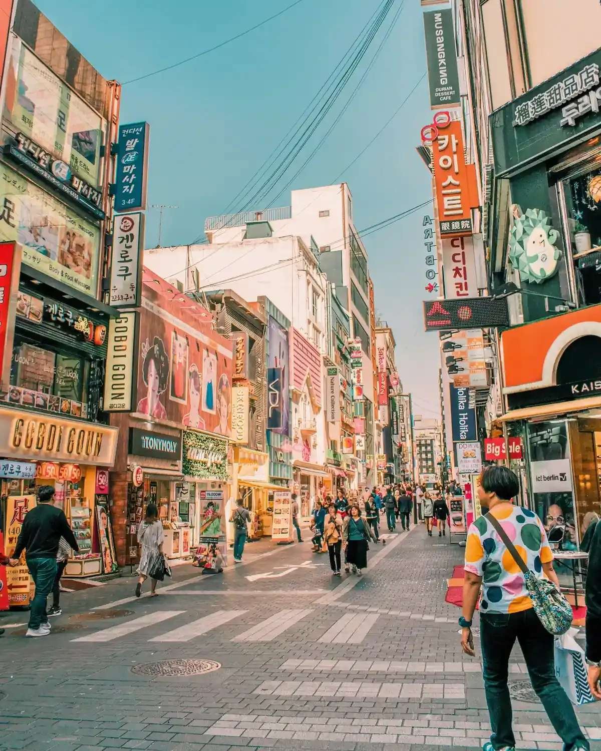 Where to stay in Seoul: vibrant Myeongdong shopping street with beauty shops and pedestrians