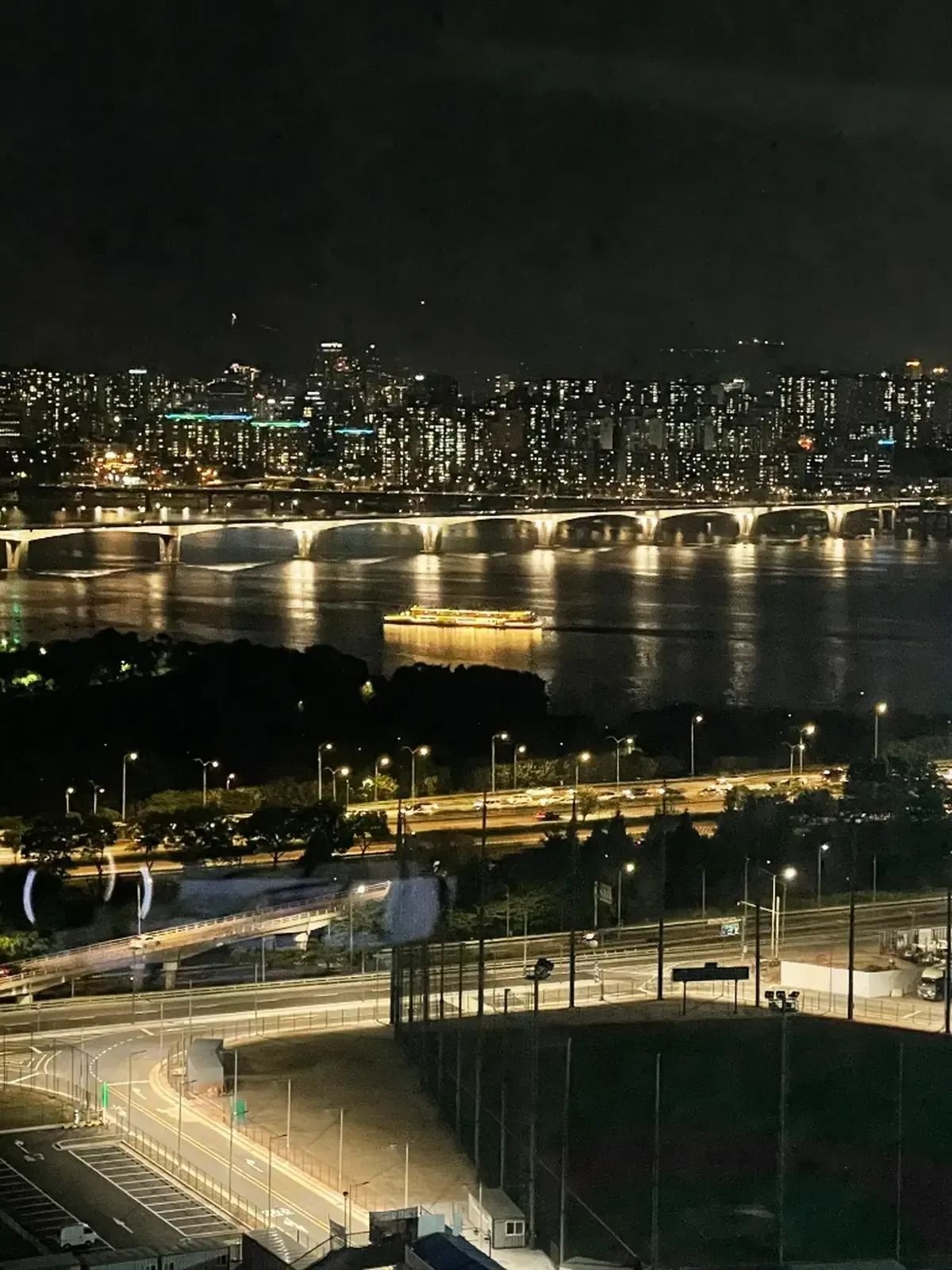 Night view of Seoul cityscape and an illuminated cruise boat on the Han River