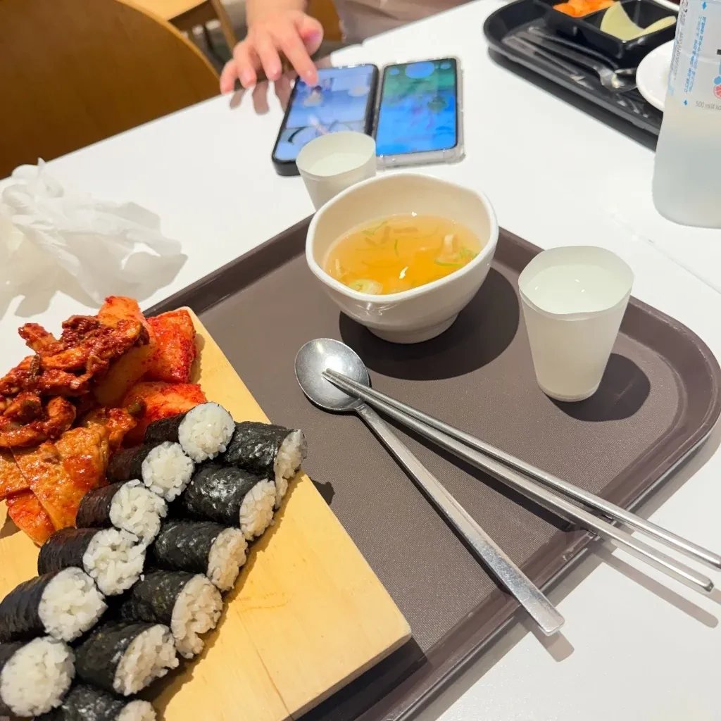 Korean bite-sized kimbap and spicy squid banchan tray at a casual bunsik restaurant in Seoul