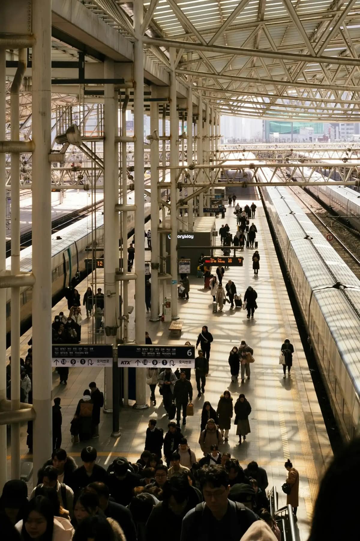 Busy Seoul Station departure platform and passengers boarding KTX bullet trains