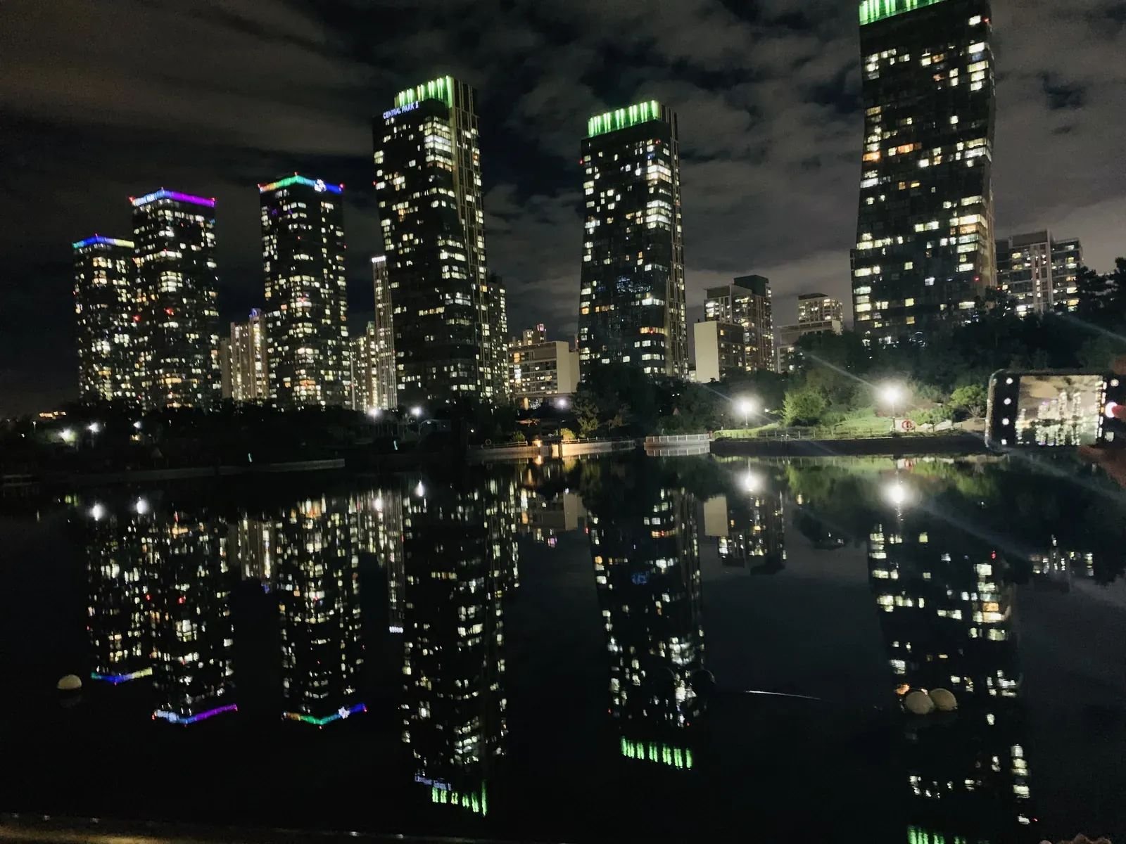Illuminated skyscrapers reflected in Songdo Central Park at night