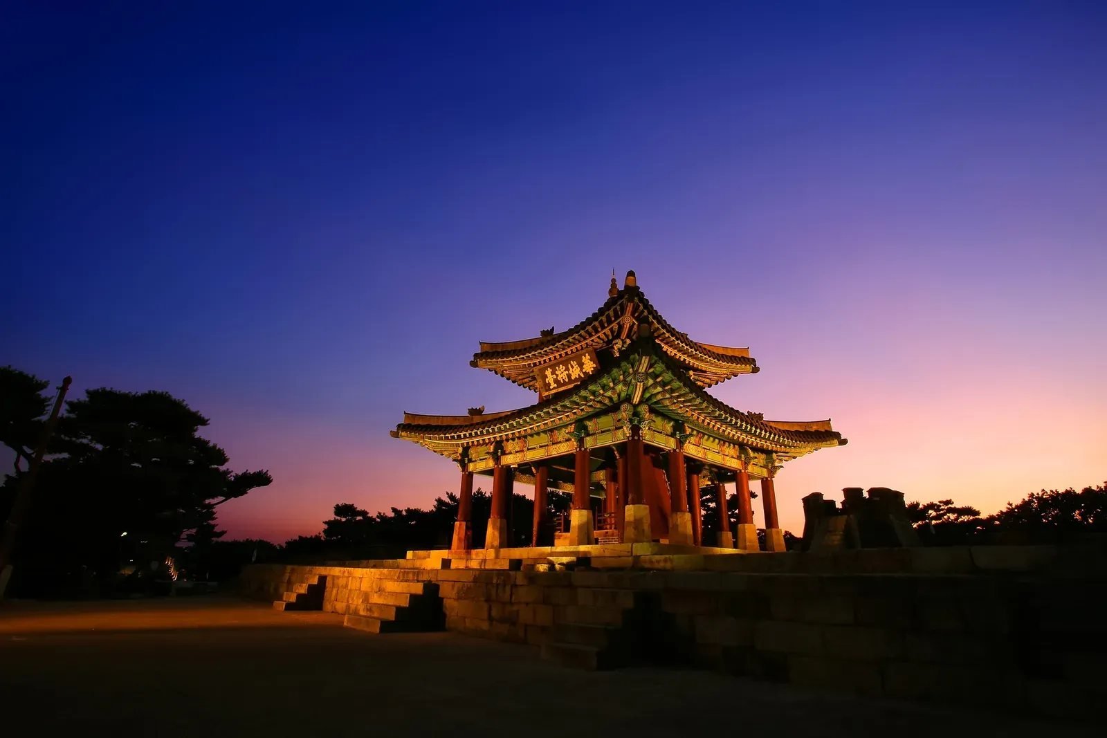 Traditional pavilion illuminated at sunset at Suwon Hwaseong Fortress