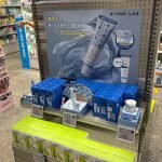 A 'Global Hot Issue' sunscreen display at an Olive Young store, featuring Round Lab's Birch Juice sunscreen.