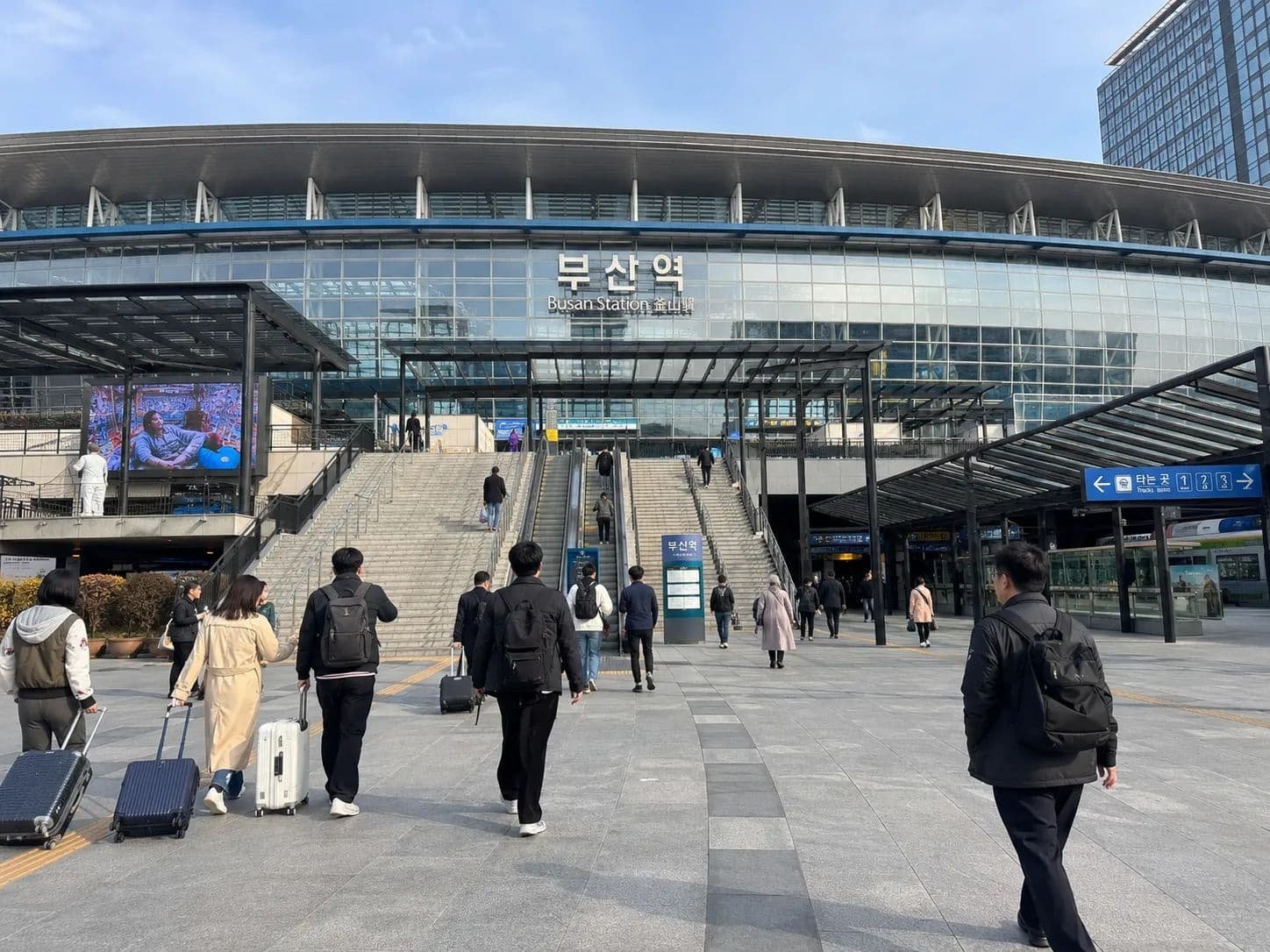 Travelers with suitcases arriving outside Busan Station in South Korea