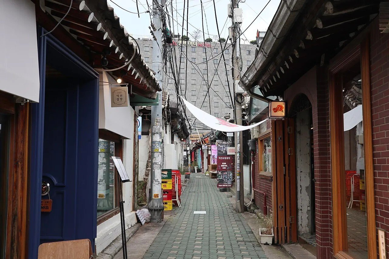 A narrow hanok-lined alley in Ikseon-dong with shops and cafes.