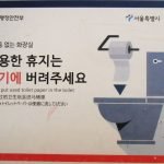 Sign explaining toilet paper disposal in a Korean public restroom