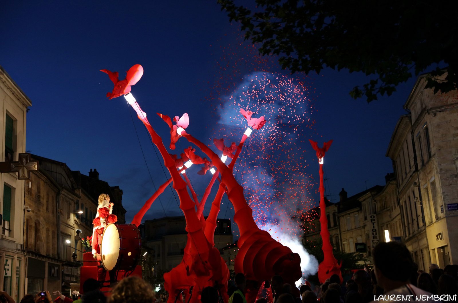 Giant red giraffe puppets from Compagnie OFF performing Les Girafes at night in France in 2018.