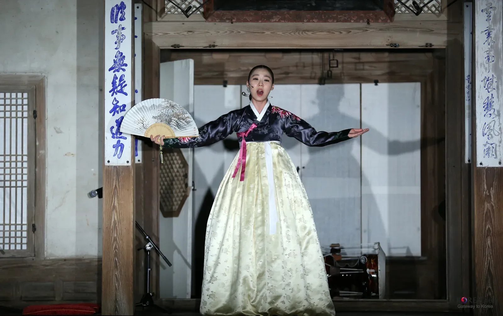 A pansori singer in hanbok performs on a traditional wooden stage during an earlier cultural program in Seoul.