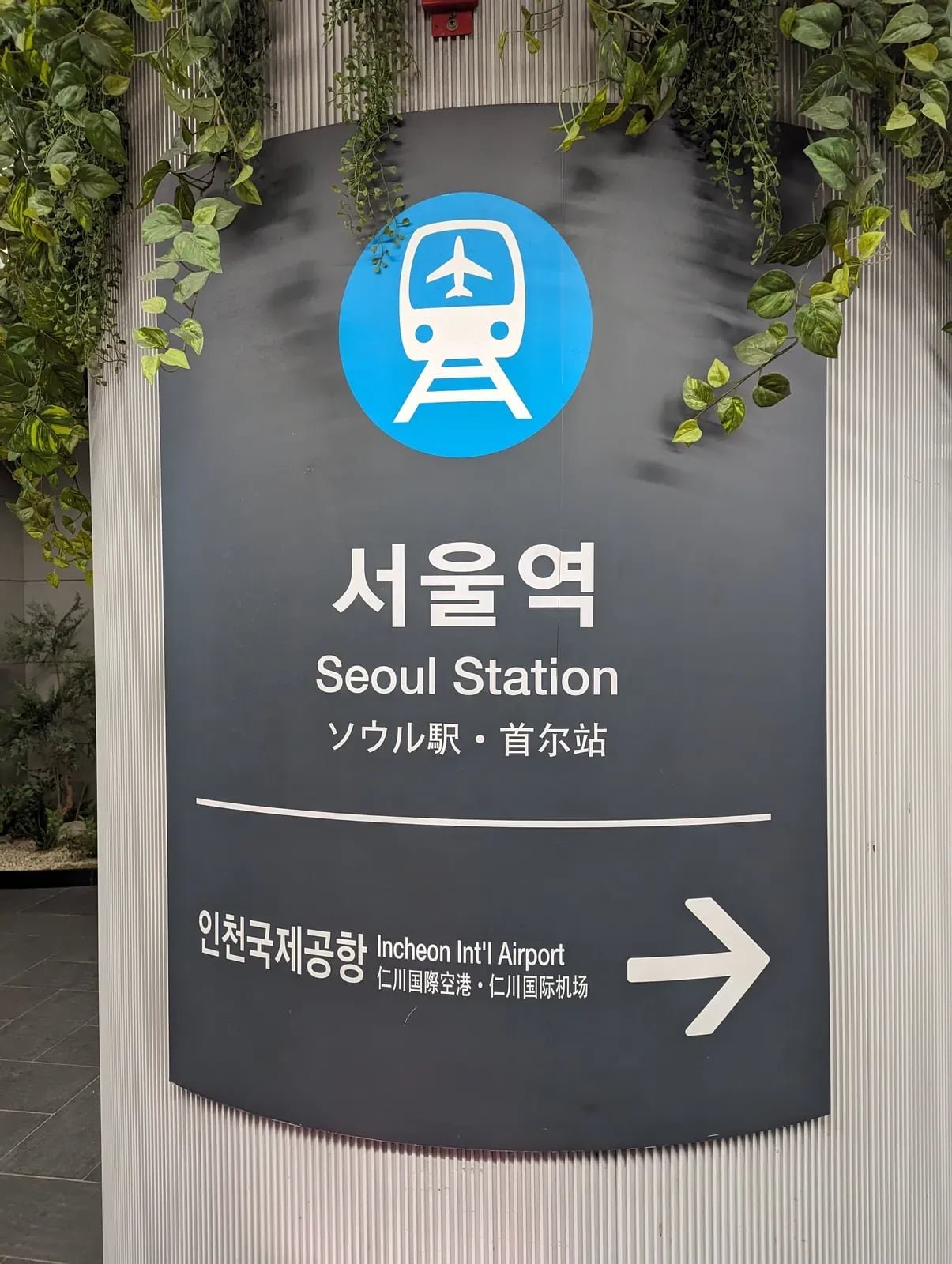 Seoul Station AREX sign with an airport train symbol and an arrow beside the Incheon International Airport label.