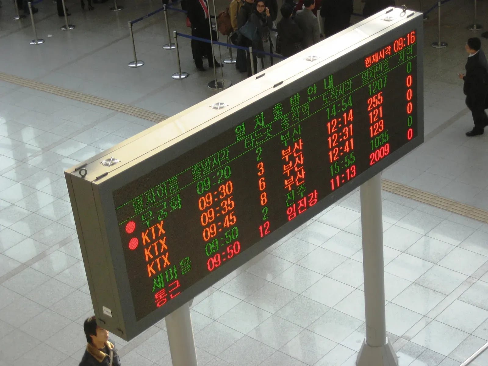 Archival photograph of a Seoul Station electronic departure board showing rows of train information in red and green.